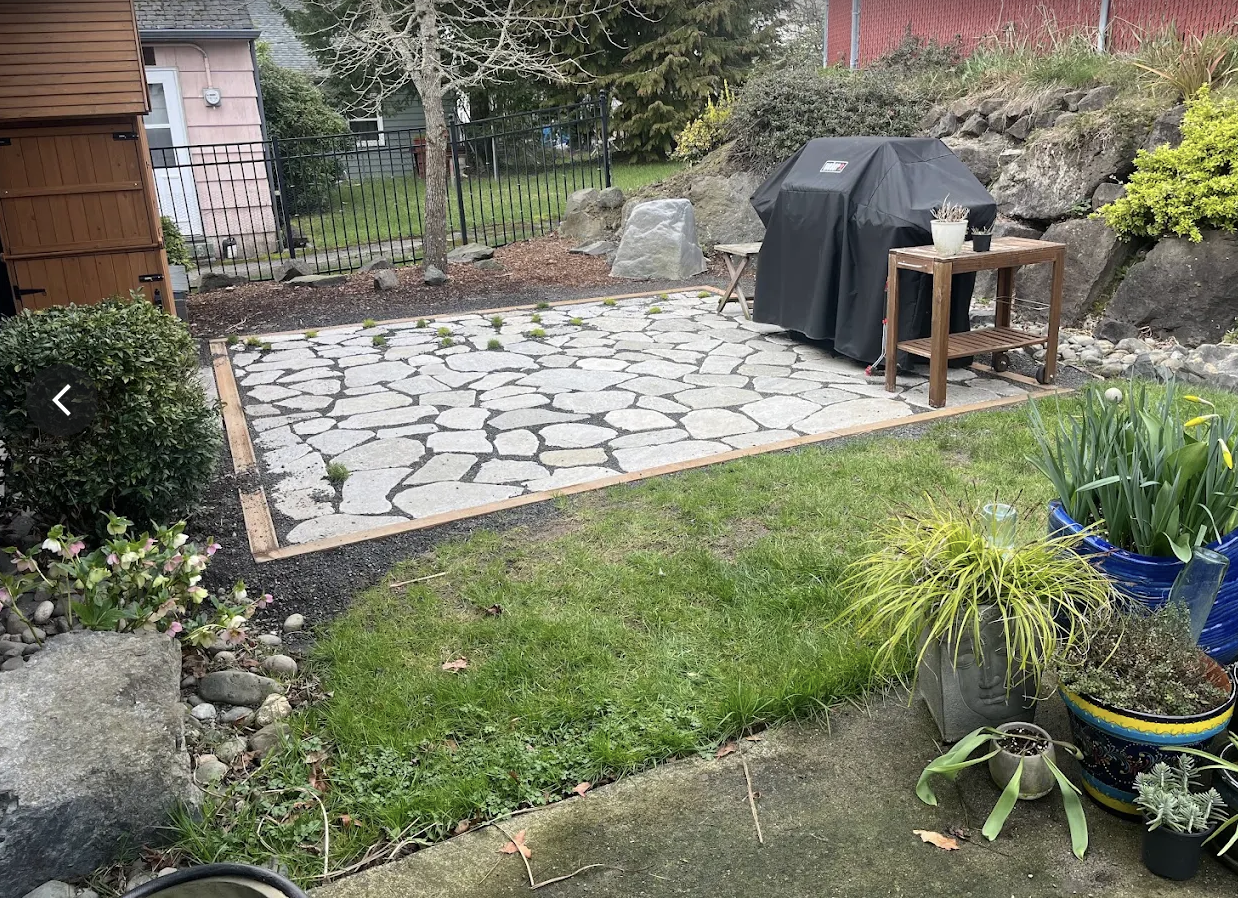 Finished flagstone patio set in gravel with a timber border beside a lawn